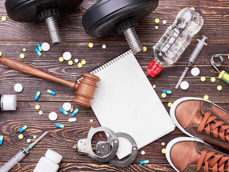 A table with pills, handcuffs and a pair of shoes.