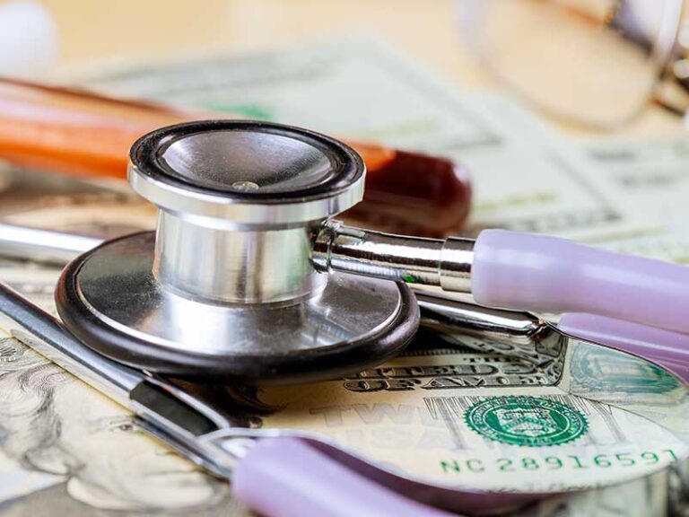 A stethoscope sitting on top of some money.
