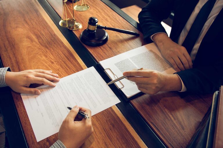 A person is signing papers at a table